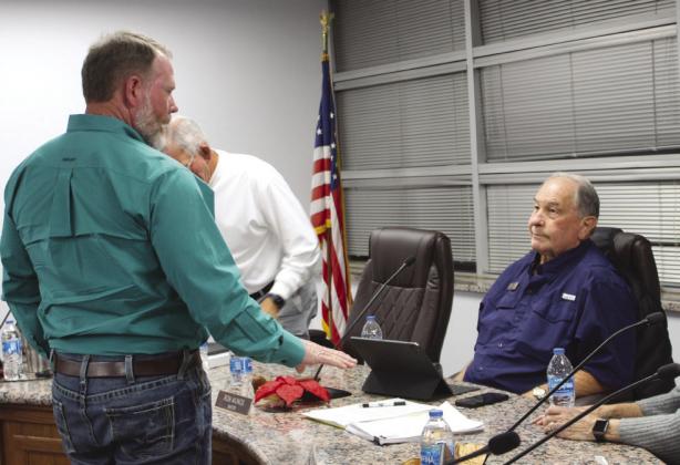 Granite Shoals Wildlife Advisory Committee President Todd Holland (left), during a break, spoke to Mayor Ron Munos at the dais Dec. 19 at a special meeting to address the feral cat control program. Connie Swinney/The Highlander