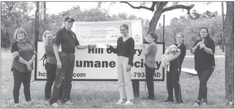 Hill Country Humane Society board members, from left, are Linda Raschke, Dani Wolff, Teresa Hudler with Shasta the dog and board secretary Jackie Haynes, holding the kitten Pandora, joined executive director Paighton Corley to thank Dan Gower (both holding a check). Gower is the cousin and executor for the estate of Art Gower, who donated $100,000 to the shelter. Martelle Luedecke/Luedecke Photography