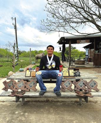 Marble Falls senior powerlifter Xavier Lopez with his medals and plaques he's won during his four years competing in the sport, including his state title medal that he's wearing. Contributed photo