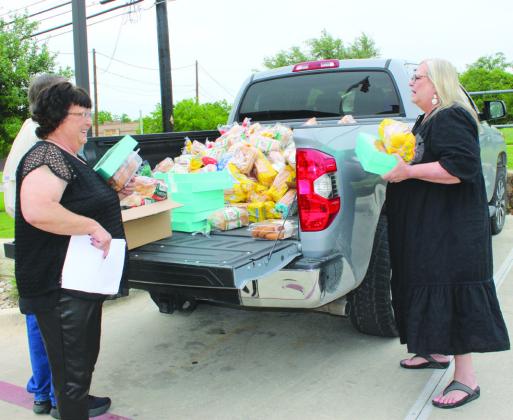 Pictured, from left, Donna Wheeler and Brandy Henry, both site coordinators for the Community Resource Center, assisted with non-perishable food donations April 19 at the Marble Falls Helping Center.