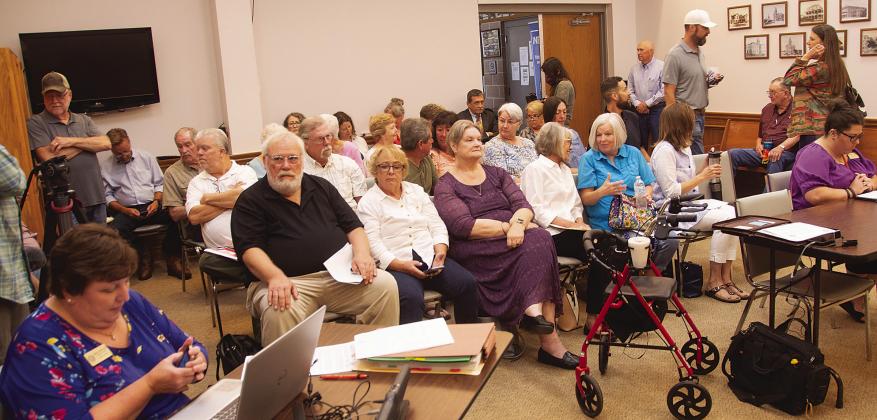 Llano County commissioners considered defunding libraries after becoming embroiled in a lawsuit that accused the local government body of censorship. Meeting attendees had to draw lots for entry into the room due to capacity issues. File photos