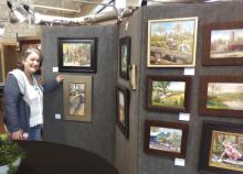 Paula Schecter, a volunteer for the Marble Falls Paint the Town, found herself enthralled April 25 with several pieces displayed at Lakeside Pavilion. The event is hosted by Highland Lakes Creative Arts. Beverly Walker/ The Highlander