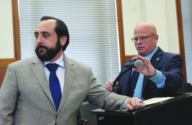 Left, Burnet County Emergency Management Coordinator Derek Marchio responds to a question about the temporary burn ban during the eclipse next month. County Commissioner Pct. 2 Damon Beierle adjusts the microphone as Marchio speaks. Raymond V. Whelan/The Highlander