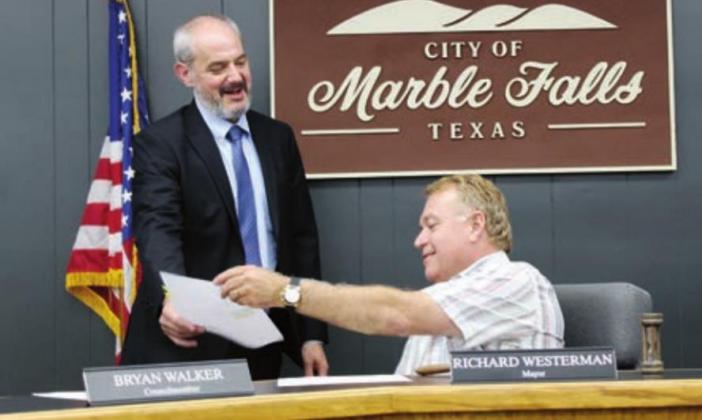 Mayor Richard Westerman shared a moment with bond counsel Gregory Miller during a break and signing of bond finance agreement documents July 20 for the Thunder Rock Public Improvement District. Connie Swinney/ The Highlander