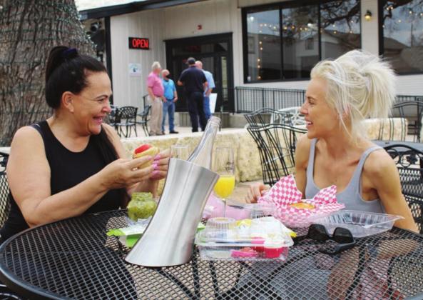 Horseshoe Bay residents Luna Vermuelen and Pam Vermeulen dined in the courtyard of Old Oak Square on Main Street in Marble Falls on March 11. Officials say restaurant sales tax receipts are a big contributor to the economic outlook for Marble Falls. 
