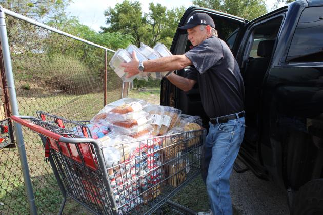 Helping Center Executive Director Sam Pearce unloaded a delivery Sept. 14 of the latest donation shipment from H-E-8. Photos by Connie Swinney/The Highlander