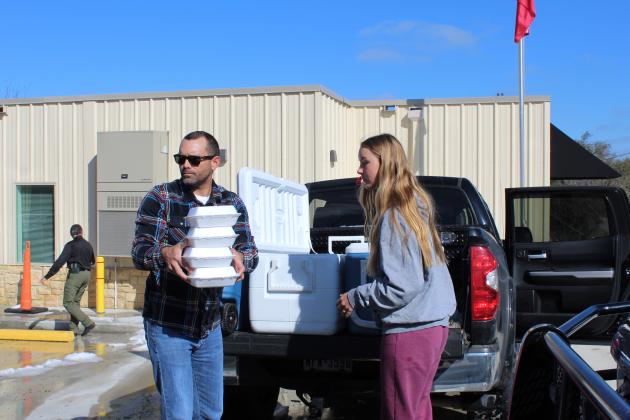 Sydney Mittelstaedt and her dad Aaron Mittelstaedt worked together to distribute food in Cottonwood Shores Feb. 19 on behalf of Highland Lakes Crisis Network. Connie Swinney/The Highlander 