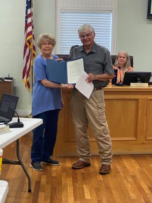 Llano Mayor Gail Lang won re-election May 1. She is pictured here at the Monday night city council meeting presenting with Mike Reagor a Family Heritage Month Proclamation. Contributed