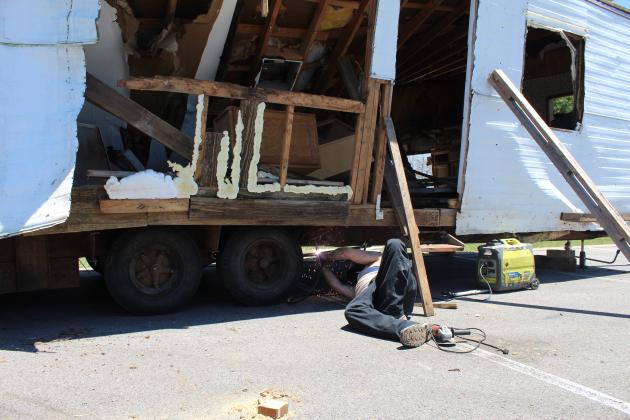 Aron Chandler received some assistance in making repairs to the damaged trailer carrying the structure in the parking of Life Marble Falls church. 