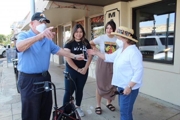 VFW Post 10376 Media Representative Dan Cone and his wife Evelyn stopped to thank Marble Falls High School art students Maile Carballo and Kandy Rojas Sept. 10 for their participation in a memorial mural on a window on Main Street in Marble Falls.