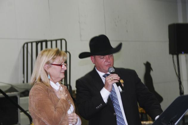 Auctioneer Scotty D. Gibbs tells Kathy Huske she has a won a vacation prize during the Highland Lakes Service League fundraising auction last month in Burnet.