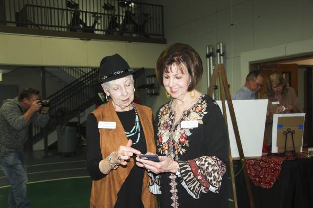Brenda Ubank (left) and Darlene Hargett review the sale of items during the recent Highland Lakes Service League fundraiser.