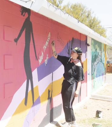 Candace McIntyre works on part of the mural she’s painting on the wall of the Cottonwood Shores Civic Center on Sunday, April 3. McIntyre, who’s majoring in art, is donating her time for the mural and the city is buying the materials. Phil Reynolds/The Highlander