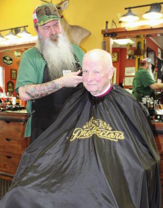 Customer Tom Chaffin and Brothers Barber and Beard owner Allan Jones offered their take on year-long restrictions on businesses related to the coronavirus. Photos by Connie Swinney/The Highlander