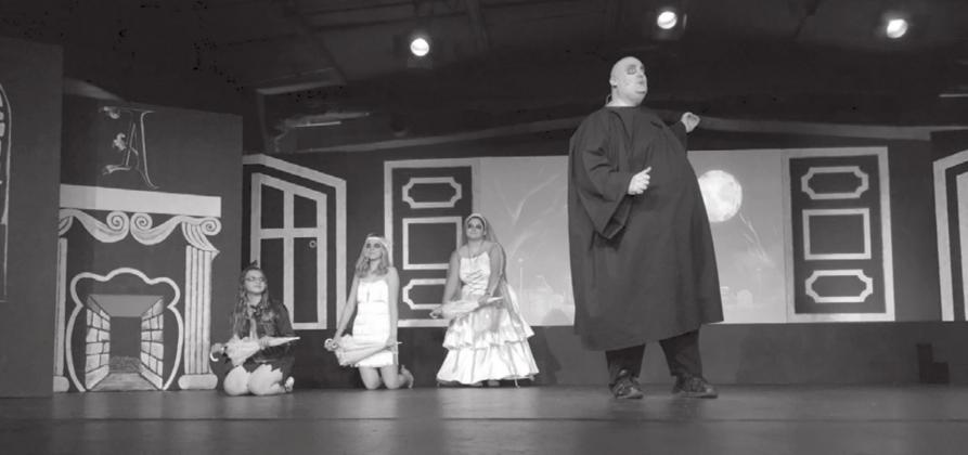 Managing Editor Lew K. Cohn, right, sings about his love of the moon as Uncle Fester in “The Addams Family Musical” at Hill Country Community Theatre while being assisted by Addams ancestors played by Victoria Davis, Madison Puckett, and Alyiah Singleton. Karina Fox/Special to The Highlander