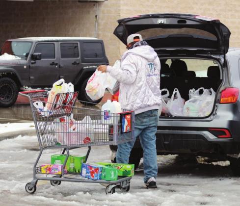 Loading groceries while navigating a slushy parking lot became a challenge for shoppers Feb. 17 at the Marble Falls HEB. Due to postponed morning truck deliveries, the store experienced shortages in everything from eggs and soups to paper goods and milk. Connie Swinney/The Highlander