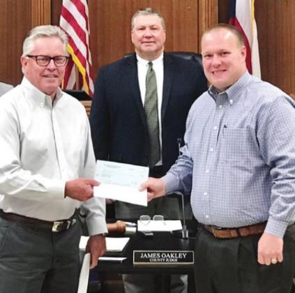 Capital Area Housing Finance Corporation president Mark Mayfield presents a check to Kevin Naumann of the Highland Lakes Crisis Network in June 2020 as part of a $100,000 donation the organization made to area non-profits last year. Mayfield will be presenting another $50,000 in donations to Burnet County organizations on Tuesday, March 23. Contributed