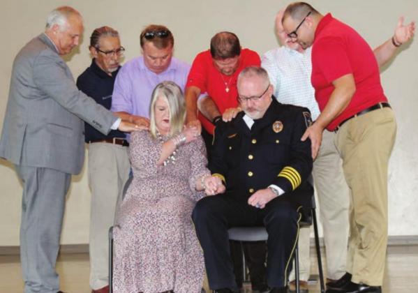 Right: New Marble Falls Police Chief Glenn Hanson, pictured here with his wife Brook and Marble Falls City Council members, participated in a biblically-inspired session of laying on of hands after he was sworn in June 29 to lead the department. Pictured with the couple, from left, are City Manager Mike Hodge and council members Rene Rosales, Mayor Richard Westerman, Reed Norman, Dave Rhodes and Bryan Walker. Photos by Connie Swinney/The Highlander