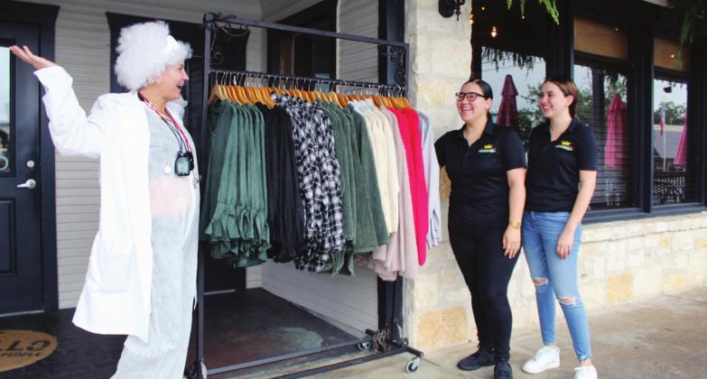Connie Swinney /The Highlander Lucero Benitez and Nadia Romo, employees at El Jardin Corona on Main Street, were impressed with Lula’s on Main owner Kelly Davis’ Doc Brown costume for the Back to the Future event on Saturday.