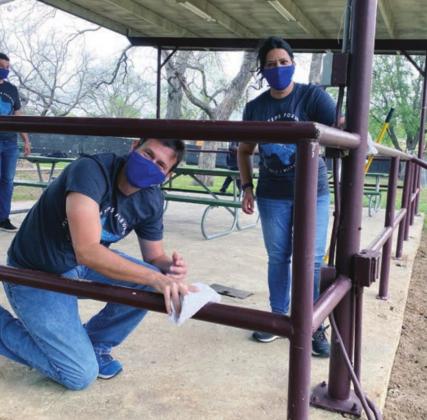 Left: LCRA employees paint the railing at an outdoor pavilion at Johnson Park in Marble Falls.