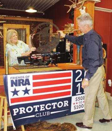 Burnet County Friends of NRA event committee members Pat Pucik and Mark McDonald unveiled live auction items Aug. 6 for an upcoming fundraiser, which had been postponed in the spring during COVID-19 venue closures. Connie Swinney/The Highlander