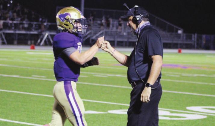 Mustangs offensive coordinator Heath Hohmann (right) called a fast-paced and balanced offensive game on Friday against the Austin Travis Rebels. He handed out plenty of fist bumps after eight Mustangs touchdowns, including to quarterback Jake Becker. Nathan Hendrix/The Highlander