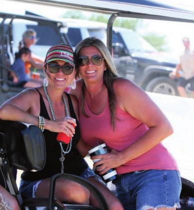 At the right and above, Shelly Laird and Ashley Reutebuch take a break from shooting clays to enjoy beverages and the shade of a golf cart at the Shoot for Coop tournament Saturday, June 13.