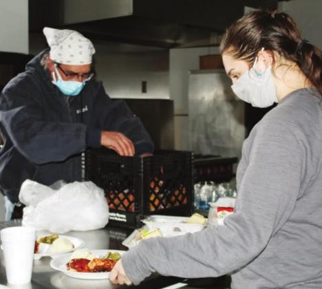 Hannah Chandler, an HLCN voluntee, pictured here with Marble Falls ISD worker Leonard Venghaus, both volunteered in food preparation at the shelter located at First United Methodist Church in Marble Falls. Connie Swinney/The Highlander