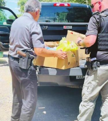 Cottonwood Shores Police Department Chief Johnny Liendo, on the left, and his police officers deliver goods to the community’s recently-opened pantry. Revenue for his department are being considered by the city council. Contributed