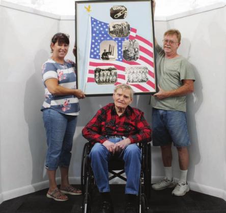 The family of Korean War veteran Robert Mead (center) received their commissioned collage from Bernie Sachs on Aug. 19. Pictured is Robert’s son Adam (right) and daughter-in-law Paula. Nathan Hendrix/The Highlander