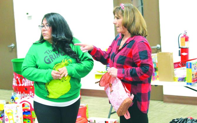 Burnet County Clerk Julie Torrez gazed to her right as Pct. 2 Justice of the Peace Lisa Whitehead offered direction during the Burnet County Santa Helper's donation drive Dec. 16, in Burnet at the Texas AgriLife Extension.