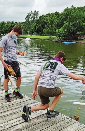 Carson Collins, left, assists Declan Howell with checking a zebra mussel settlement sampler on Inks Lake to make sure none of the invasive species have latched onto the device. Declan’s Eagle Scout project will help serve as an early warning system for Inks Lake. Contributed