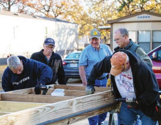  The Texas Ramp Project provided the labor to install a wheelchair ramp for an elderly couple at their home at 115 Happy Oaks, Kingsland, on Thursday, Dec. 10. Left: Robert Thiesen, Richard Lewis, Wayne Davis, Alan McCaleb and Dave Zinnecker of the Texas Ramp Project work on the base of a ramp for a Kingsland couple. 
