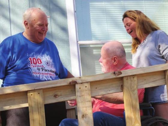 Don Barlow, left, shows William Proctor, center, and his daughter, Joni, the new ramp the Texas Ramp Project built at the Proctor home in Kingsland on Thursday, Dec. 10.
