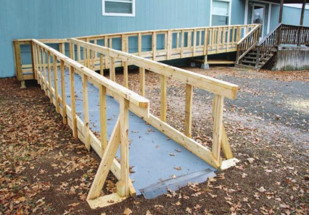 Ramp Revamp: Workers with The Texas Ramp Project install a wheelchair ramp for an elderly couple at their home at 115 Happy Oaks in Kingsland. 