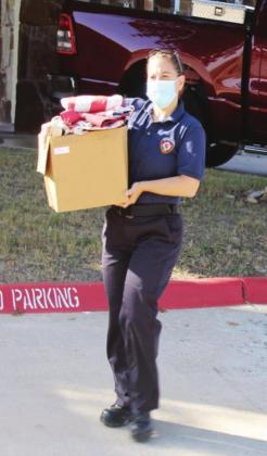 Marble Falls firefighter Katie Baxter carries a box full of flags to be retired Saturday, Nov. 7, at FirstCapital Bank of Texas in Marble Falls. 