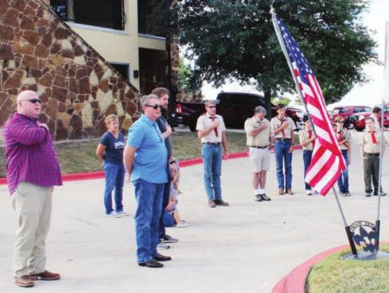 Those in attendance at the flag retirement ceremony held by Boy Scout Troup 284 of Marble Falls sing the national anthem to honor the flag.