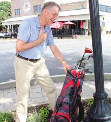Downtown business owner Bernie Sachs recreated the scene where he found his missing golf clubs Oct. 19 when a good samaritan apparently placed them after they fell out of the back of his pickup. Connie Swinney/The Highlander