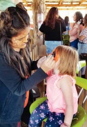 Right: Lylie Jones of Kingsland was a festive walking doll after her face was painted at Sweetberry Farm.