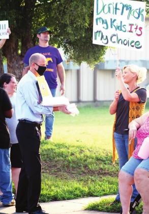 Approximately 80 people showed up at the Marble Falls ISD administration building, 1800 Colt Circle, on Wednesday, Sept. 1 to protest the school board’s decision to reinstate a mask mandate at schools. Attendees and their children (below) brought signs bearing messages against the requirement. MFISD Superintendent Chris Allen (right) provided donuts and water to the crowd. At one point, Allen was asked and agreed to answer questions from the group. Photos by Nathan Hendrix/The Highlander