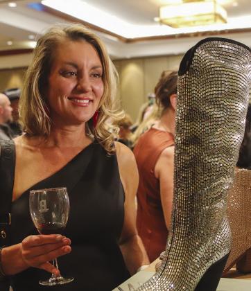 Brandie Gibson admired a sparkling boot Nov. 30 at the 2023 Wine Women &amp; Shoes fundraiser hosted by the Marble Falls Education Foundation at Horseshoe Bay Resort. Find more photos on Page 2 and 3. Martelle Luedecke/Luedecke Photography
