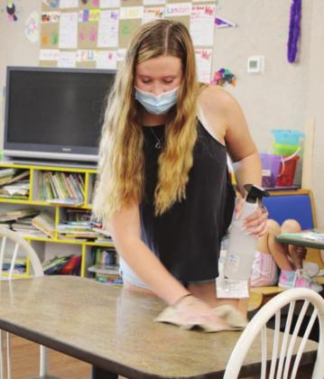 Right: Staff members at the Boys &amp; Girls Club, including Emma McAndrews (pictured), sanitize tables, chairs and other surfaces every two hours in an effort to prevent the spread of COVID-19.