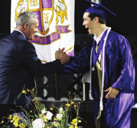 MFISD Athletic Director Rick Hoover bolted on to the stage to give the diploma to his son, Hayden. Hoover watched his son on the football field, then coached him one last time on the soccer field this season. Nathan Hendrix/The Highlander