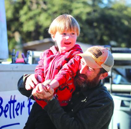 Four-year-old August Otte with his dad Robert Otte, held one of the rainbow trout that Texas Parks and Wildlife Department released into Hamilton Creek Dec 28. See the story below and find more photos on Page 3. Grace Gates/ Luedecke Photography