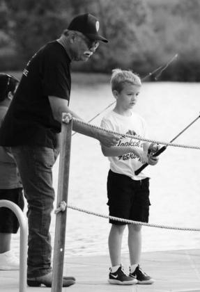 Cottonwood Shores Police Chief Johnny Liendo was an active participant at the Fishing with the Police event at LBJ Yacht Club and Marina on Saturday. He helped seven-year-old Hunter Ratliff hunt for fish at the dock. Nathan Hendrix/The Highlander hief Johnny Liendo was an