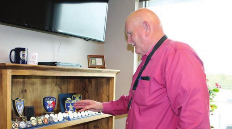 Over the years, Marble Falls Police Chief Mark Whitacre collected coins, patches and other items denoting accolades and enhancements at the local agency. Connie Swinney/The Highlander