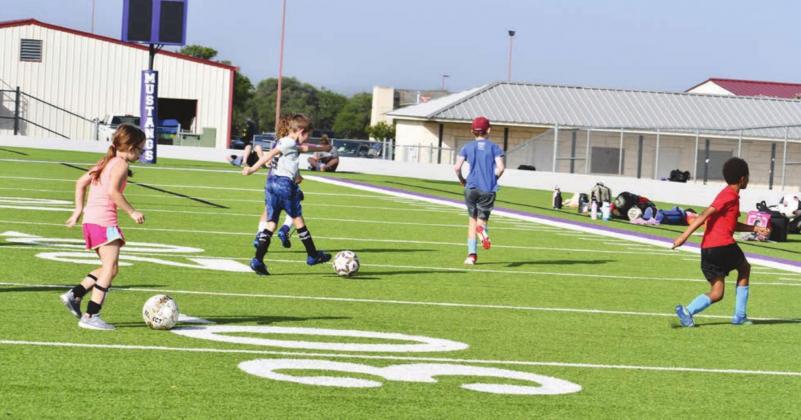 The camps make a mad dash to shooy goals before taking water break at the Marble Falls ISD soccer camp. Photos by Mark Goodson/ The Highlander