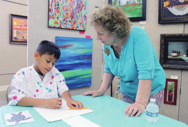 William DeChene received some guidance from artist, volunteer and co-chairwoman Evelyn Acosta-Cone on June 14 during the Highland Arts Guild week-long summer children’s camp. 