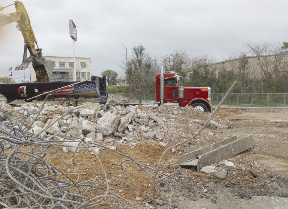 Huge trucks came and went most of the day to remove the chunks of concrete, knots of re-bar, melted wires and other carbonized debris from the lot the Mayfield Building in Marble Falls downtown business area once occupied. Beverly Walker/The Highlander