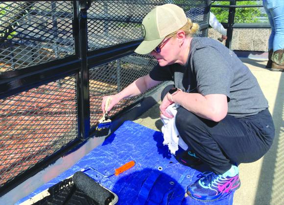 LCRA employee Lyn Corliss painted the walkway fencing at Granite Shoals City Hall during LCRA's Steps Forward Day on April 12. During the annual day of service, LCRA employees worked on 36 community